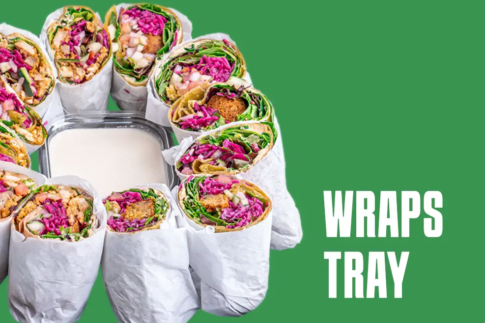 A tray of nine colorful wraps filled with vibrant vegetables and falafel, arranged around a central container of creamy sauce, evokes the freshness of Mediterranean restaurants near me. Set against a green backdrop, the words WRAPS TRAY highlight this delicious lunch option. Each wrap is wrapped in white paper.