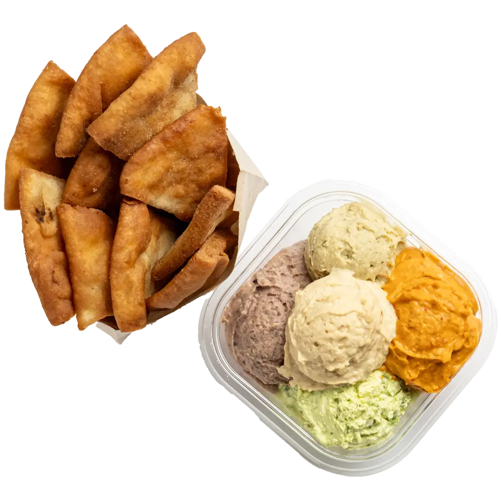 A container with five creamy dips: orange, light green, beige, tan, and gray. Nearby is a small basket of golden-brown pita chips. This delectable combo could be a star at local lunch places near me that highlight bold flavors and enticing textures for a perfect culinary contrast.